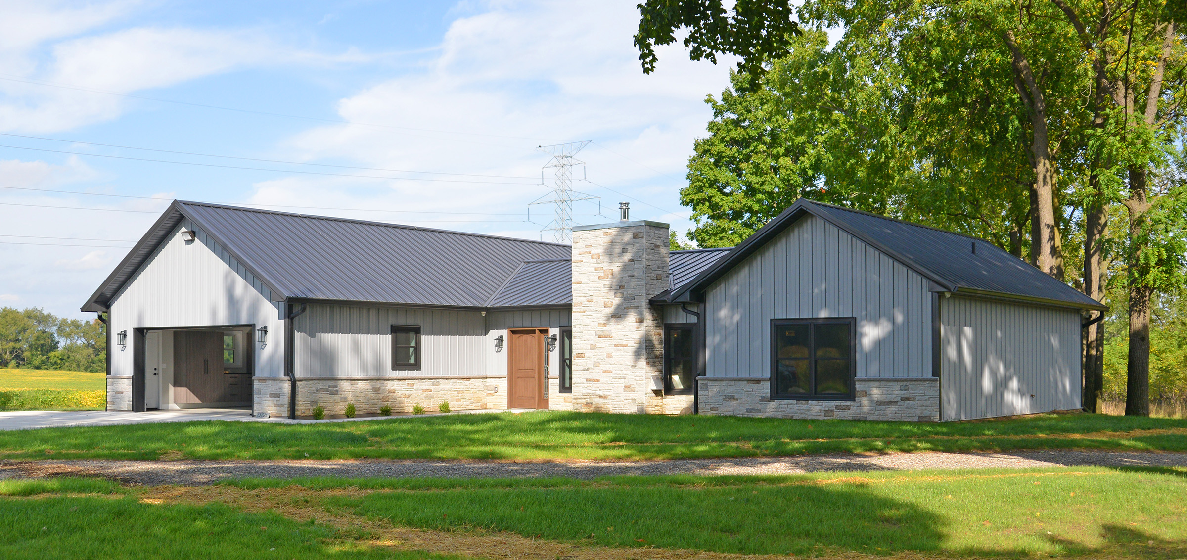 gray and dark gary pole barn home with stone siding