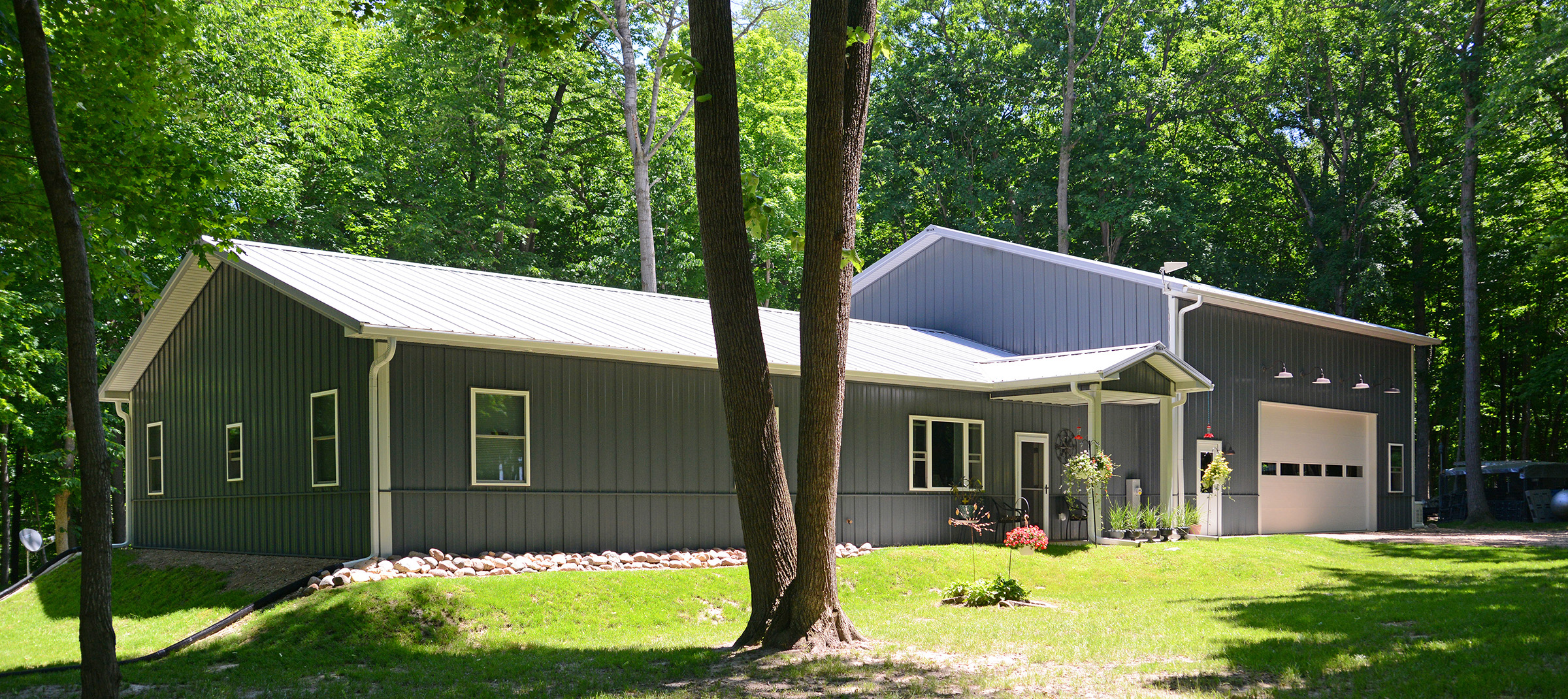 dark blue residential postframe building with white trim